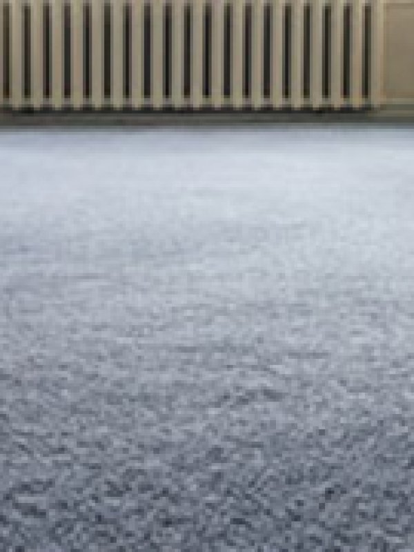 Interior close-up photo of blue carpet floor and heater on the background